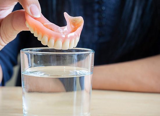 Close up of patient about to soak their dentures