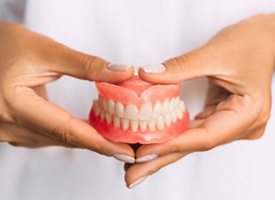 Close up of dentist holding dentures