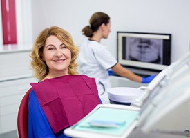 Woman in maroon bib in dental chair awaiting exam results